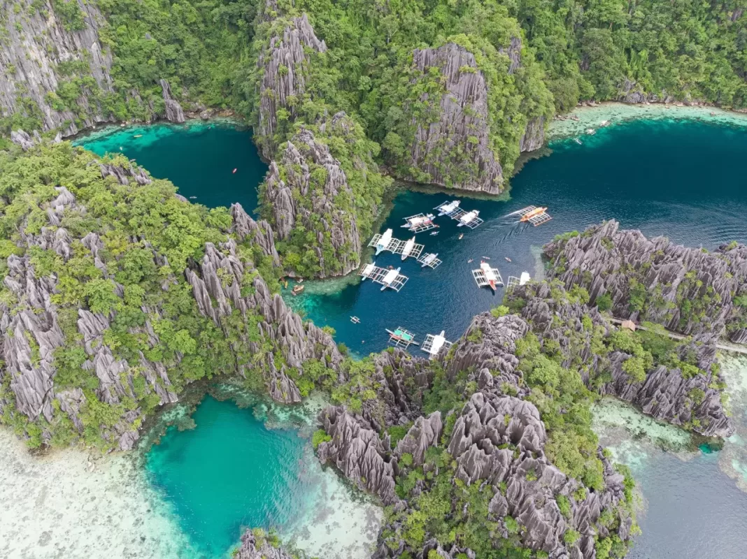 Aerial view of Twin Lagoon in Coron, Palawan with turquoise waters, dramatic limestone cliffs, and island-hopping boats