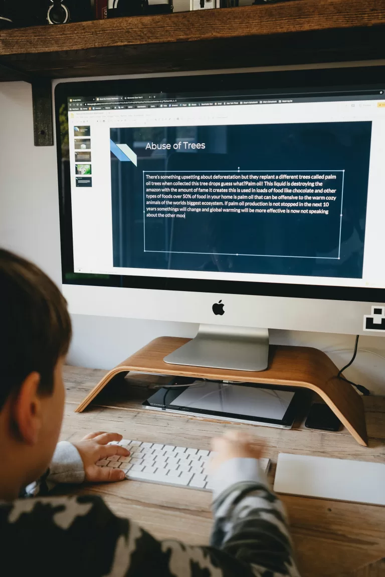 Boy typing on a desktop keyboard