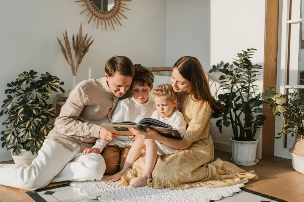 family of 4 reading a book