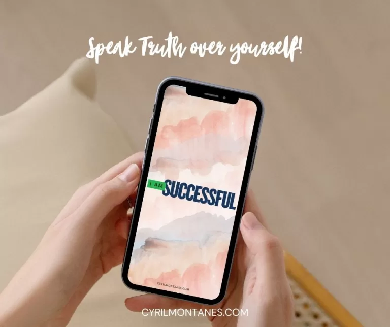 Hand holding a phone displaying an ‘I AM SUCCESSFUL’ wallpaper with watercolor background, overlaid text says ‘Speak Truth over yourself!’ and website URL cyrilmontanes.com