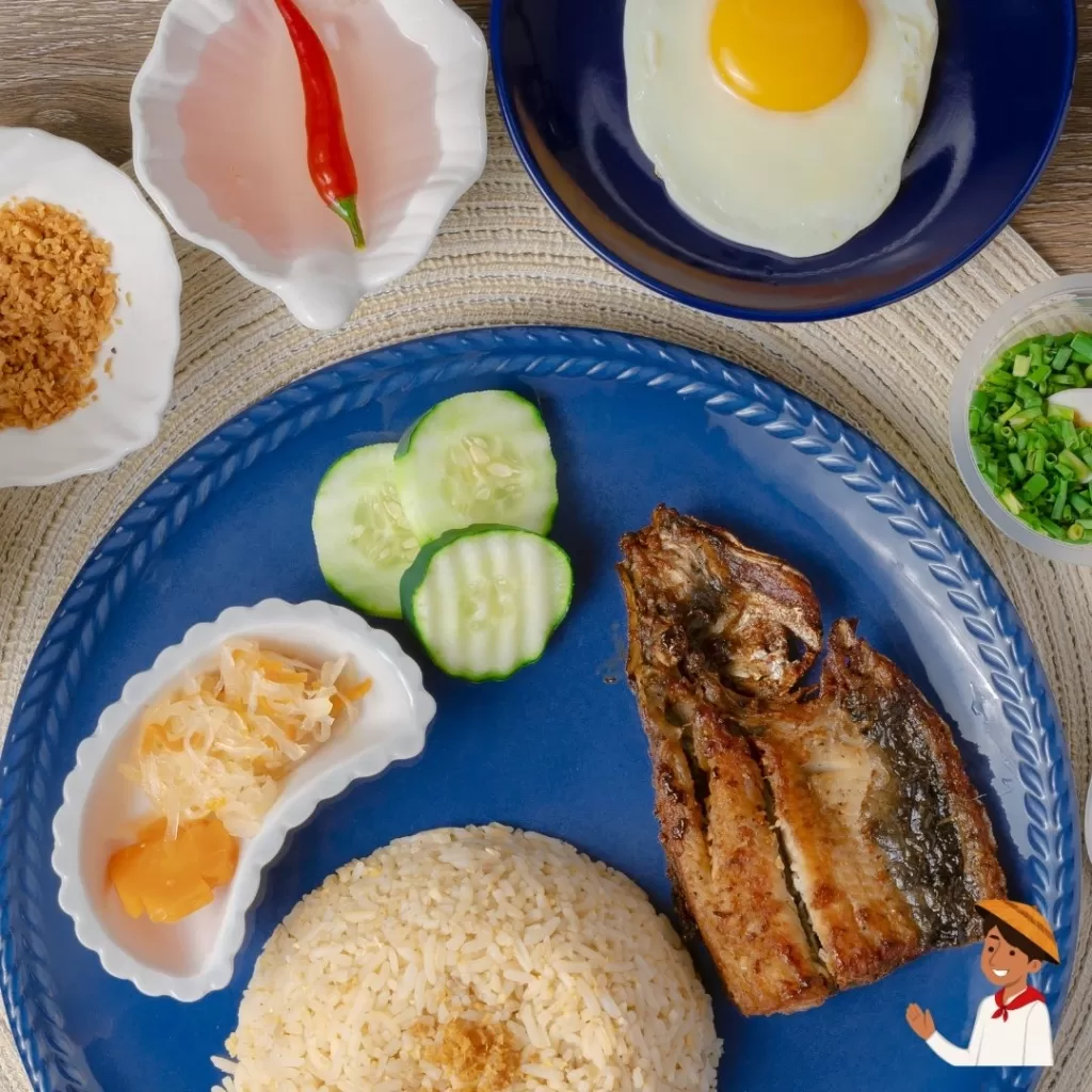 Filipino daing na bangus or milkfish breakfast with garlic rice, fried egg, and pickled vegetables.