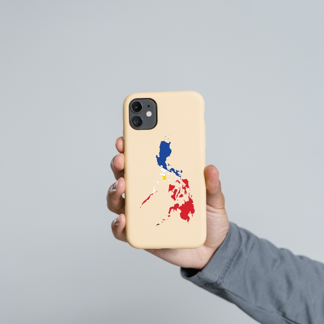 Beige phone case with Philippine map in flag colors held in hand.